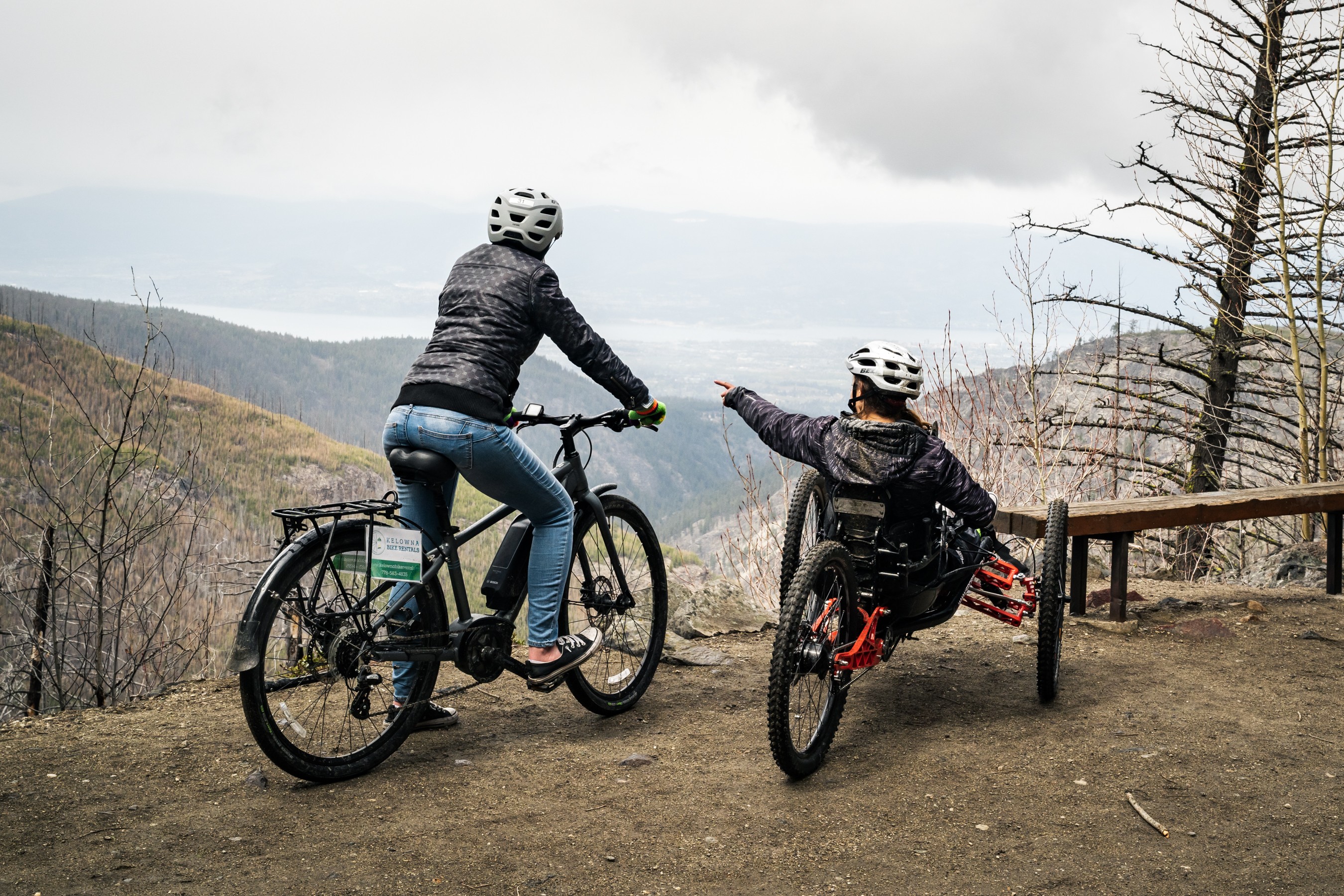 Two cyclists, one on an adaptive bicycle. 