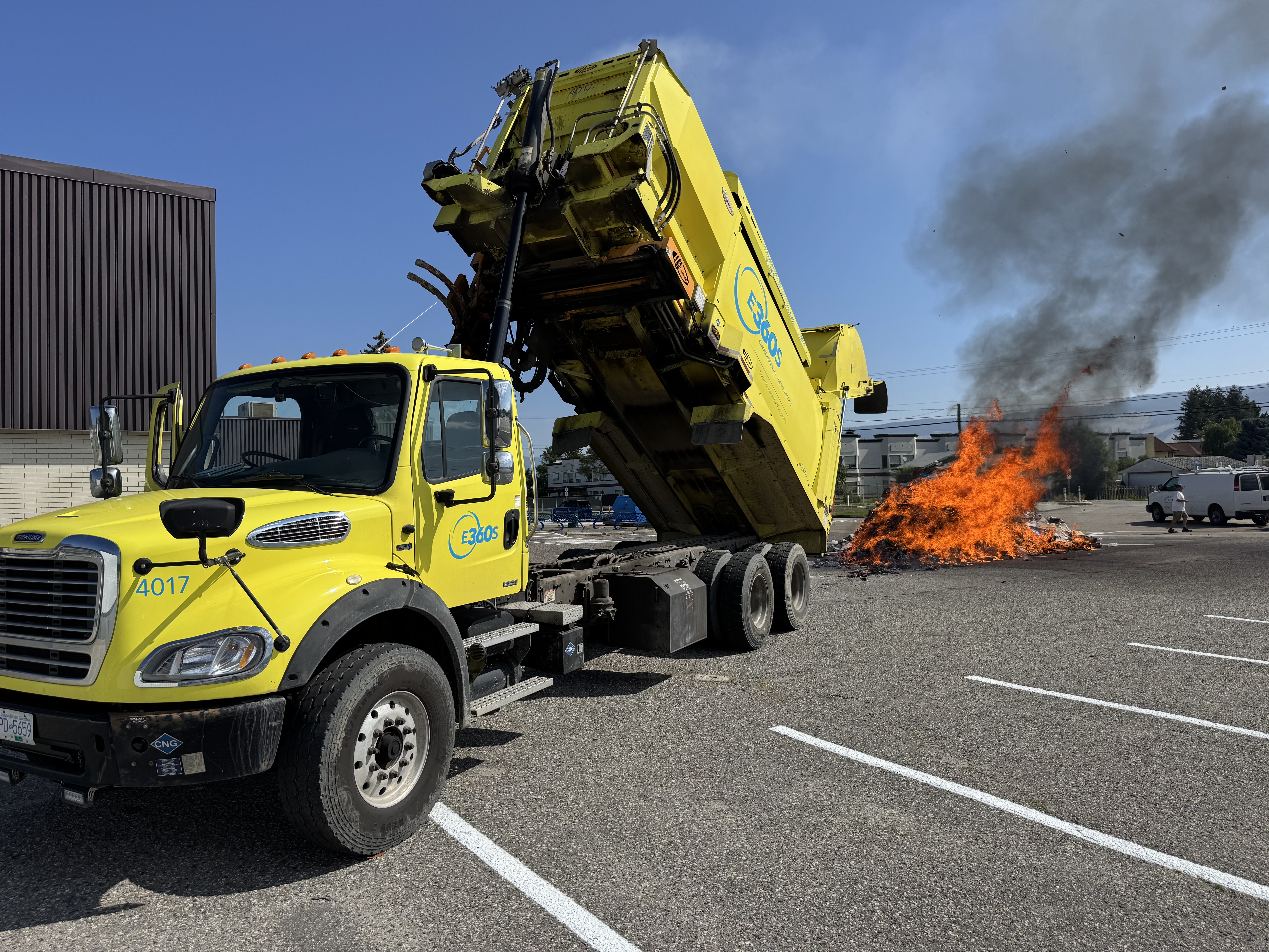 A recycling truck with a pile of waste on fire due to hazardous waste. 
