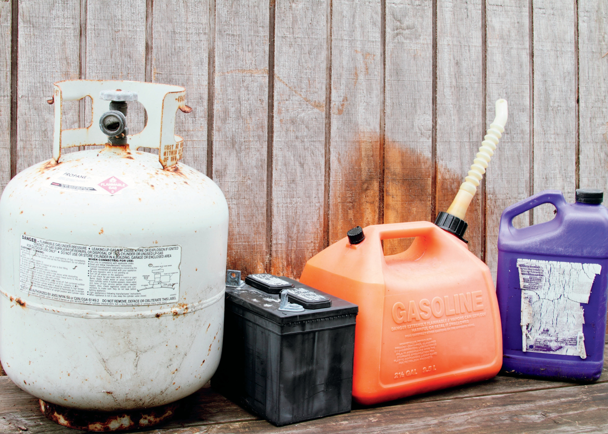 Hazardous waste items, including propane tank, battery, gas can and chemicals.